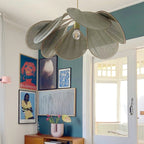 This Clérachic pendant lamp in a sage-green version hangs against a teal gallery wall hung with colourful pop-art prints.