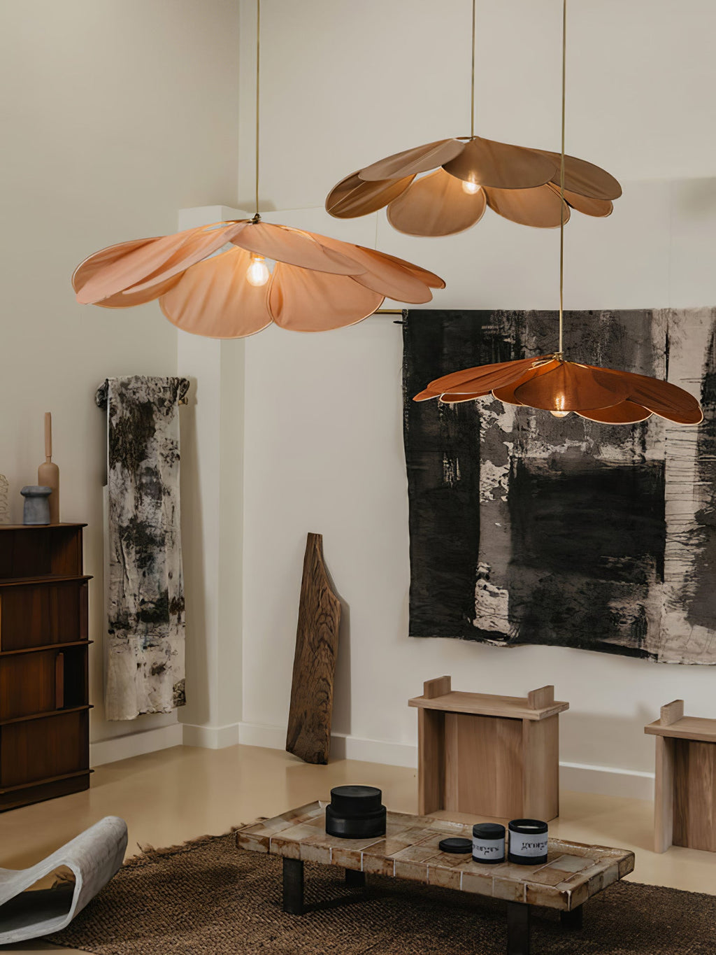 Two of these Clérachic pendant lamps, one terracotta and one copper, hang in a minimalist room with abstract wall art and a low bench.