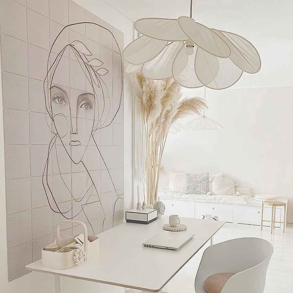 Two of these Clérachic pendant lamps in white petals hang beside a line-drawing mural and dried pampas grass on a white desk.