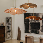 Two of these Clérachic pendant lamps, one blush pink and one copper, hang in a room with black-and-white abstract art on the wall.