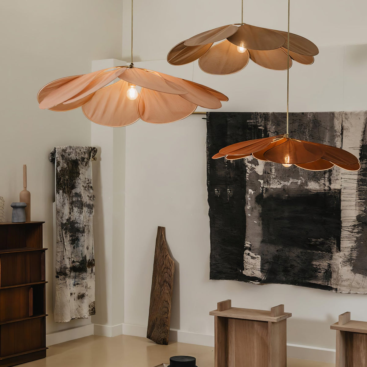 Two of these Clérachic pendant lamps, one blush pink and one copper, hang in a room with black-and-white abstract art on the wall.
