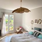 This Clérachic pendant lamp in tan petals hangs above a bed near French doors that open onto an olive-tree garden.