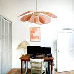 This Clérachic pendant lamp in blush pink fabric petals hangs above a wooden desk in a home office corner.