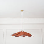 This Clérachic pendant lamp in terracotta petals hangs from a plain white ceiling with panel moulding, its bulb visible beneath.