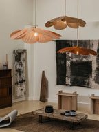Two of these Clérachic pendant lamps in terracotta petals hang above a minimalist living room with black-and-white abstract art.