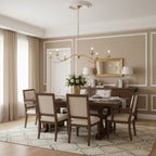 In gold finish without lampshades, this Clérachic chandelier hangs above a dark wood table beneath a gilt mirror.