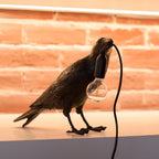 White raven lamp lit beside a wall in soft light