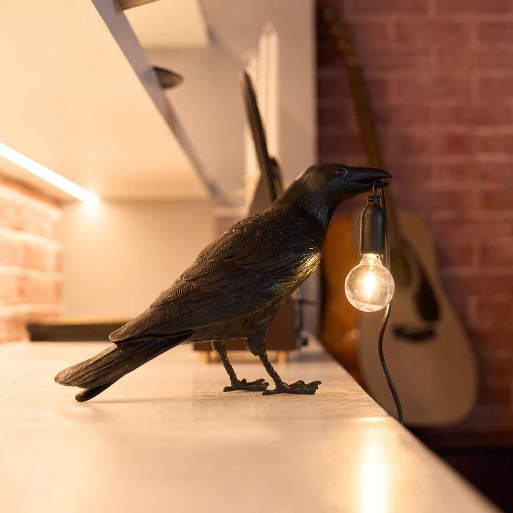 Raven table lamp shown from the side with exposed bulb