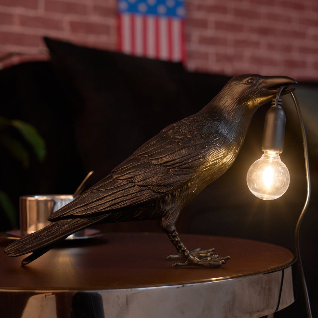 Raven lamp shown in resting pose with warm light