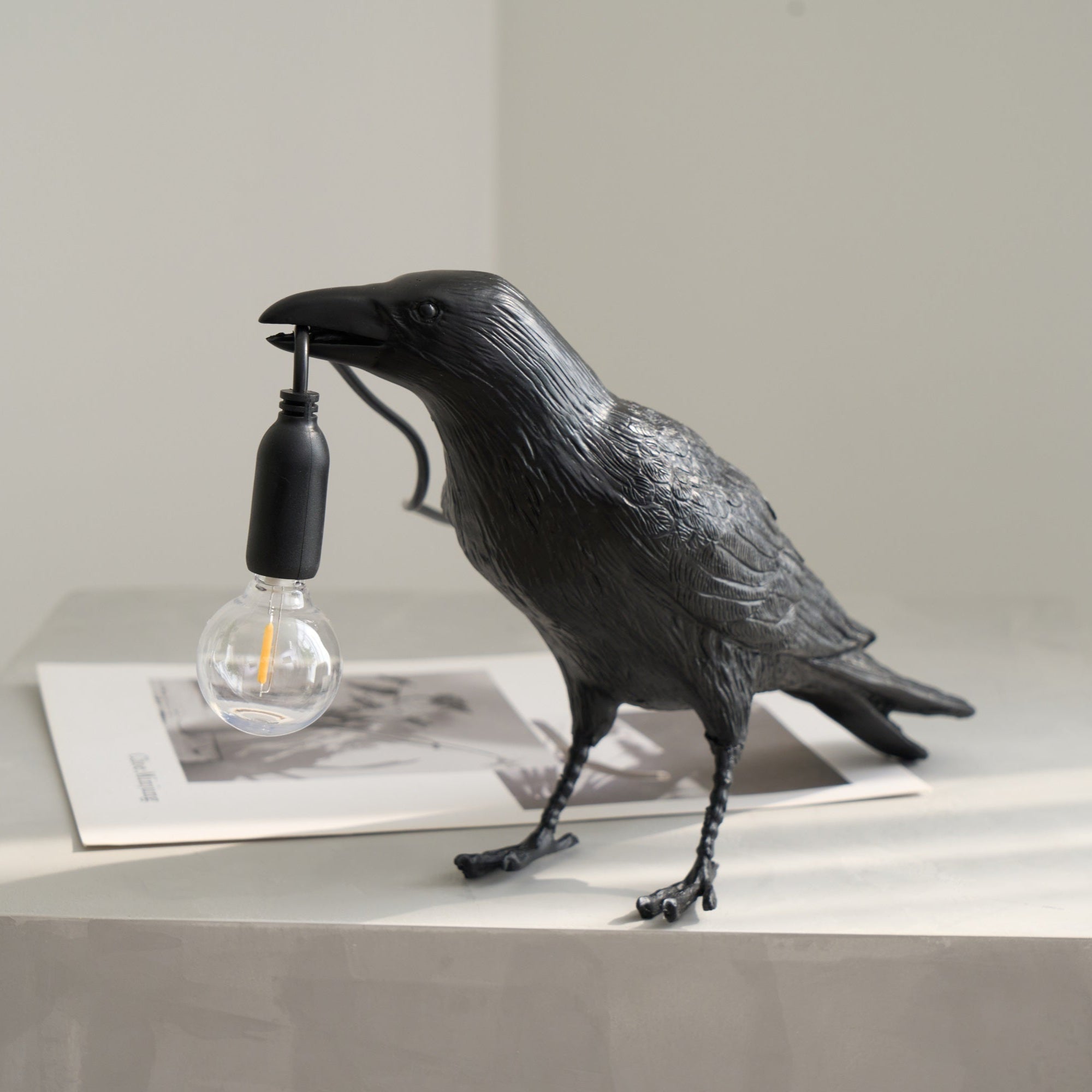 Raven resin lamp detail of beak and warm Edison bulb