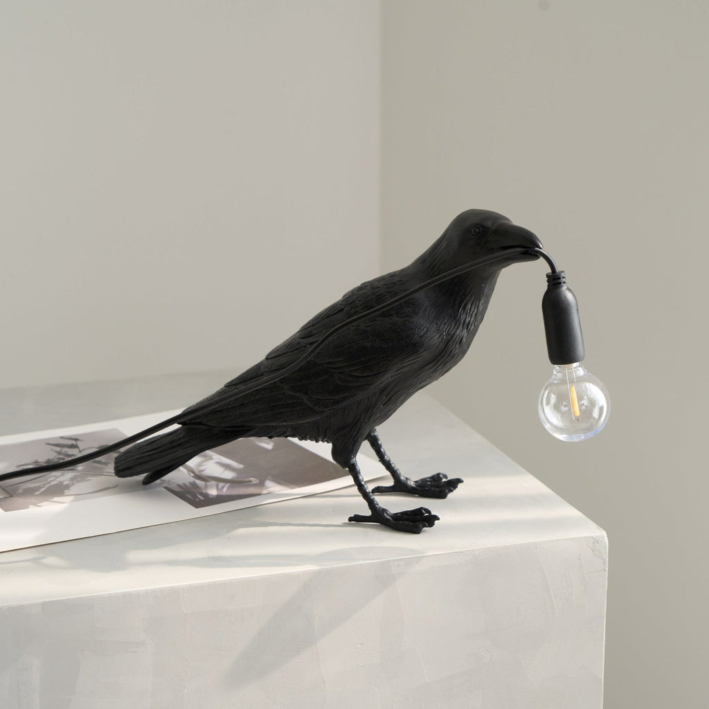 Black raven resin lamp casting warm amber light