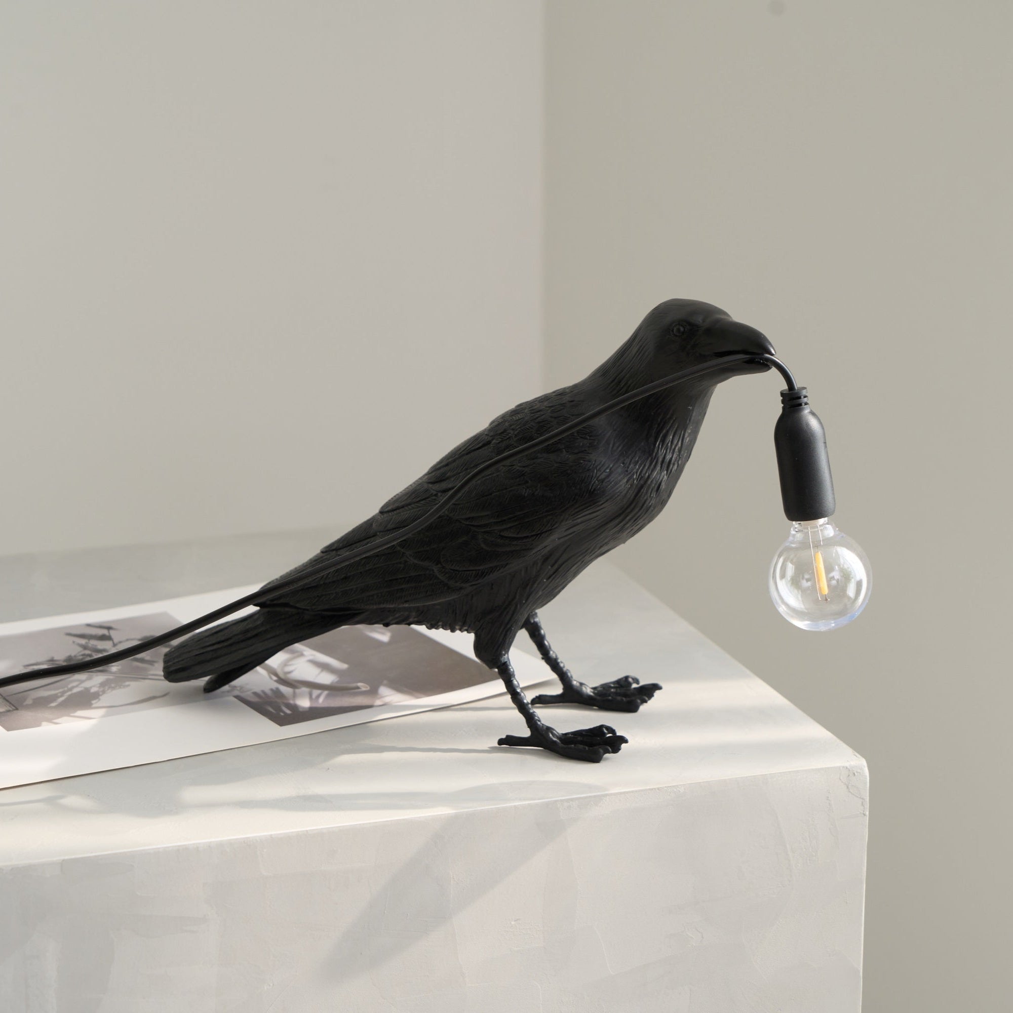 Black raven resin lamp casting warm amber light