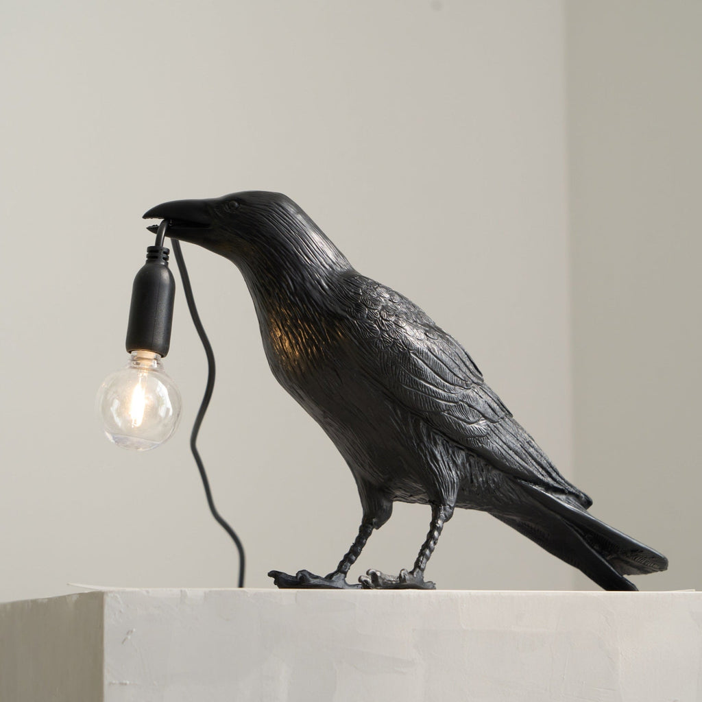 Raven lamp close-up showing sculpted head and Edison bulb