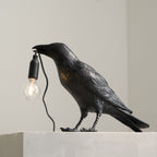 Raven lamp close-up showing sculpted head and Edison bulb