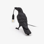 White resin raven lamp perched with an Edison bulb