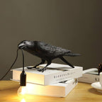 Raven table lamp glowing on a desk in a dim room