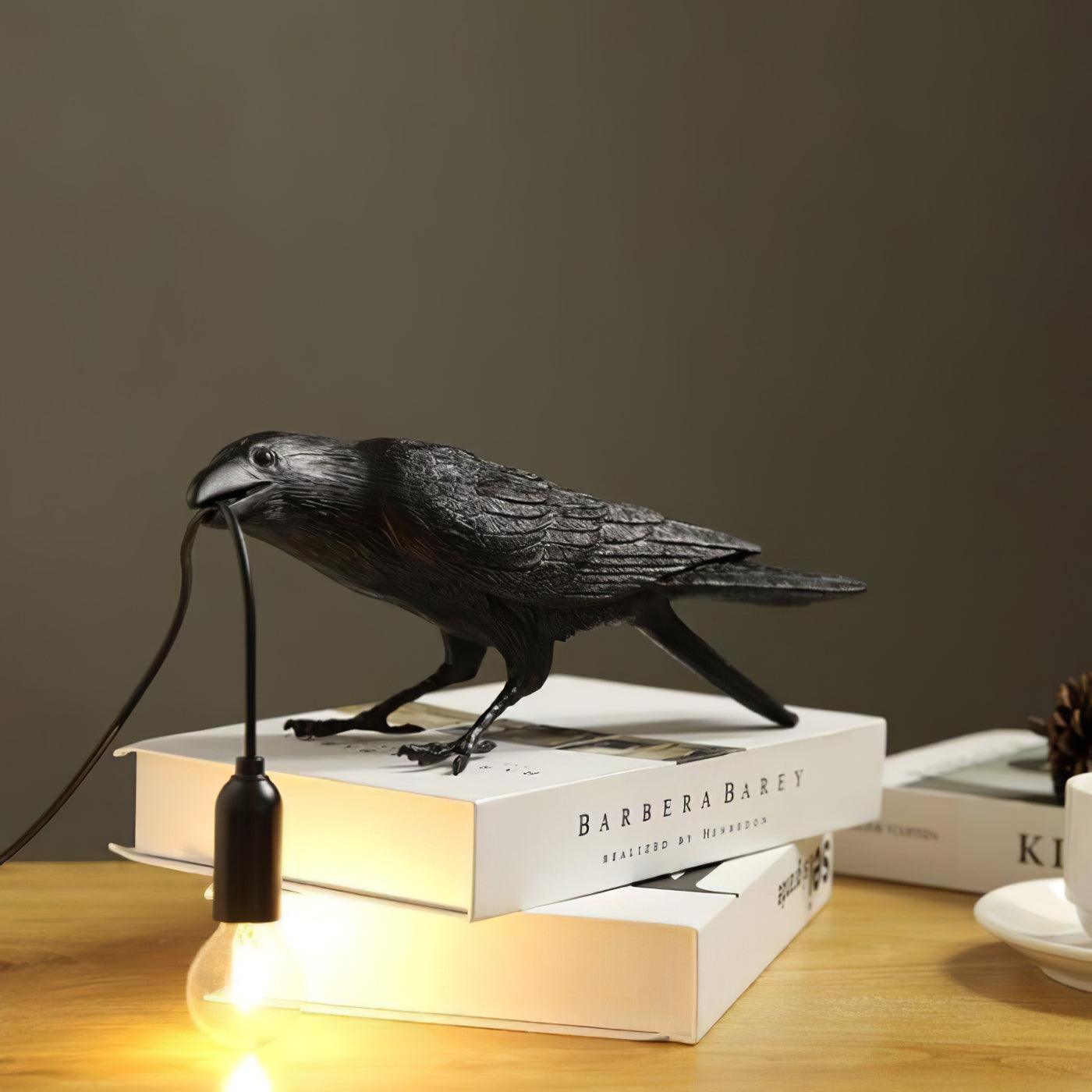 Raven table lamp glowing on a desk in a dim room