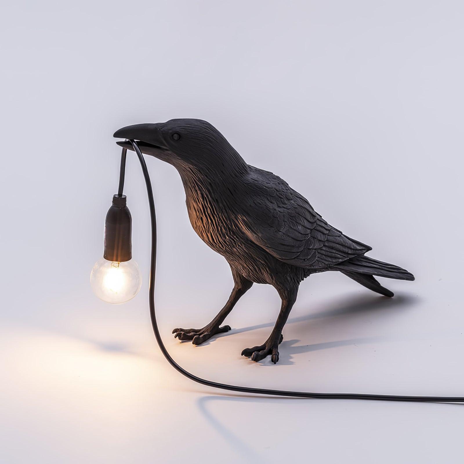 Black raven sculpture lamp with warm exposed filament bulb