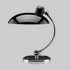Photographed on a plain grey backdrop, this black Clérachic desk lamp stands at full length.
