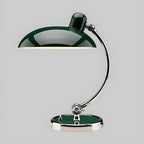 A green Clérachic desk lamp with a matching green base, shown on a plain grey backdrop.
