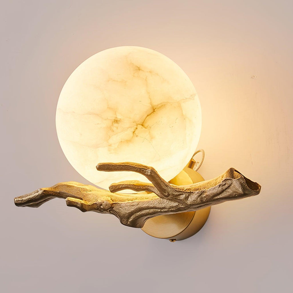 A closer product view of the lit Clérachic wall light, the marble globe glowing warmly against a plain wall.