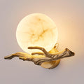 A closer product view of the lit Clérachic wall light, the marble globe glowing warmly against a plain wall.