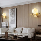 Two Clérachic sconces flank a framed artwork on a wood-panelled wall above a cream sectional sofa.