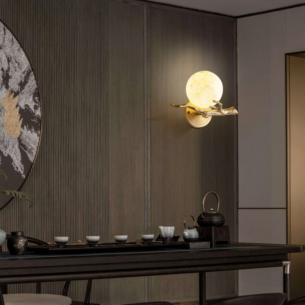 Mounted high on a wood-panelled wall, the Clérachic sconce lights a moody room set with a teapot and small cups.