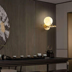 Mounted high on a wood-panelled wall, the Clérachic sconce lights a moody room set with a teapot and small cups.