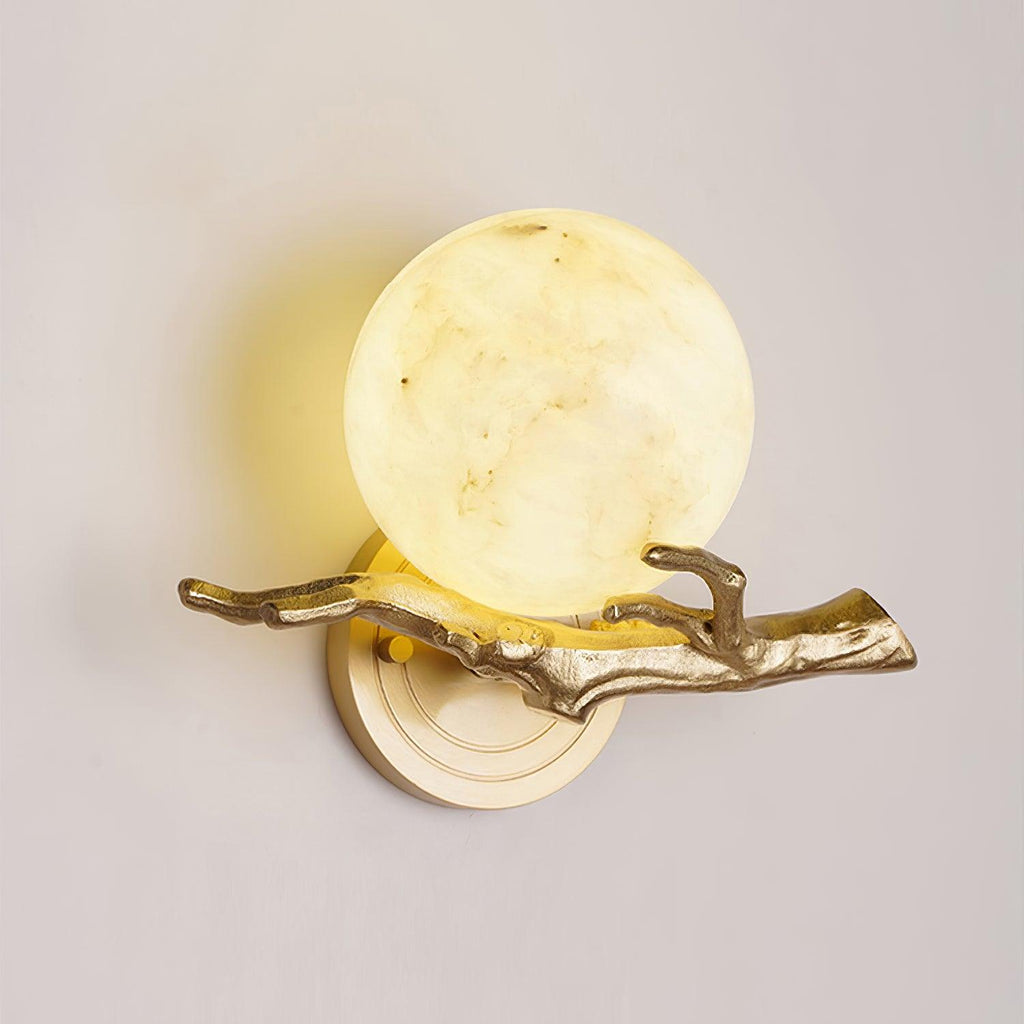 A closer angled view of the lit Clérachic sconce against a plain wall, showing the globe shade's warm glow from below.