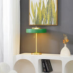 Revolve table lamp lit warmly beside a chair