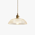 Unlit 25 cm ribbed glass shade of this Clérachic pendant, on a polished brass fitting against a plain white background.