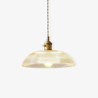 Glowing softly on a plain off-white background, this Clérachic pendant shows its ribbed shade lit from within.