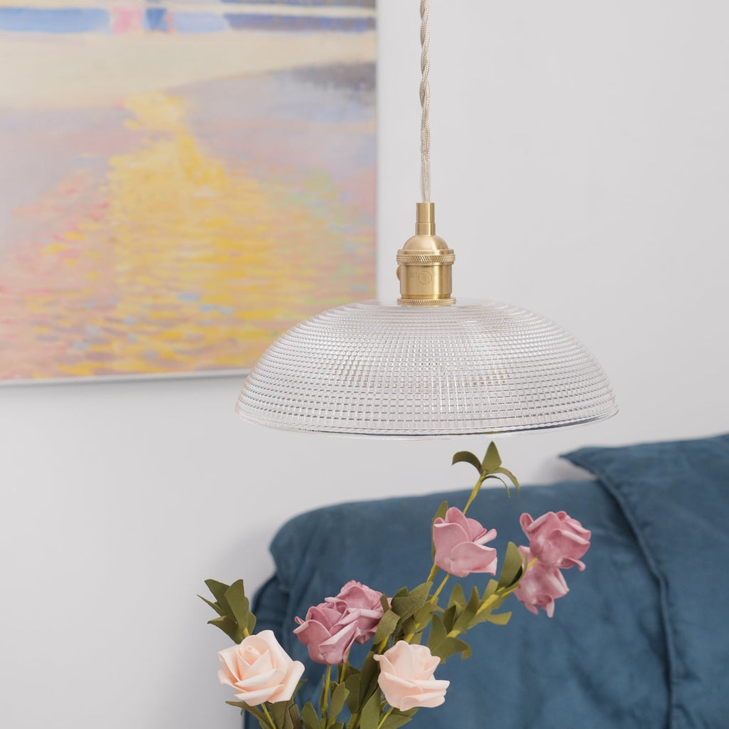 A lower angle near the blue sofa, pink roses close beneath this Clérachic pendant's unlit shade.