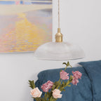 A lower angle near the blue sofa, pink roses close beneath this Clérachic pendant's unlit shade.