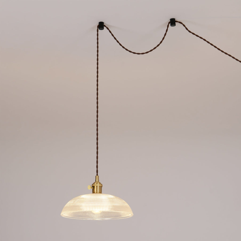 This Clérachic pendant is shown as a swag light, its cord looped between two wall hooks before dropping to the shade.