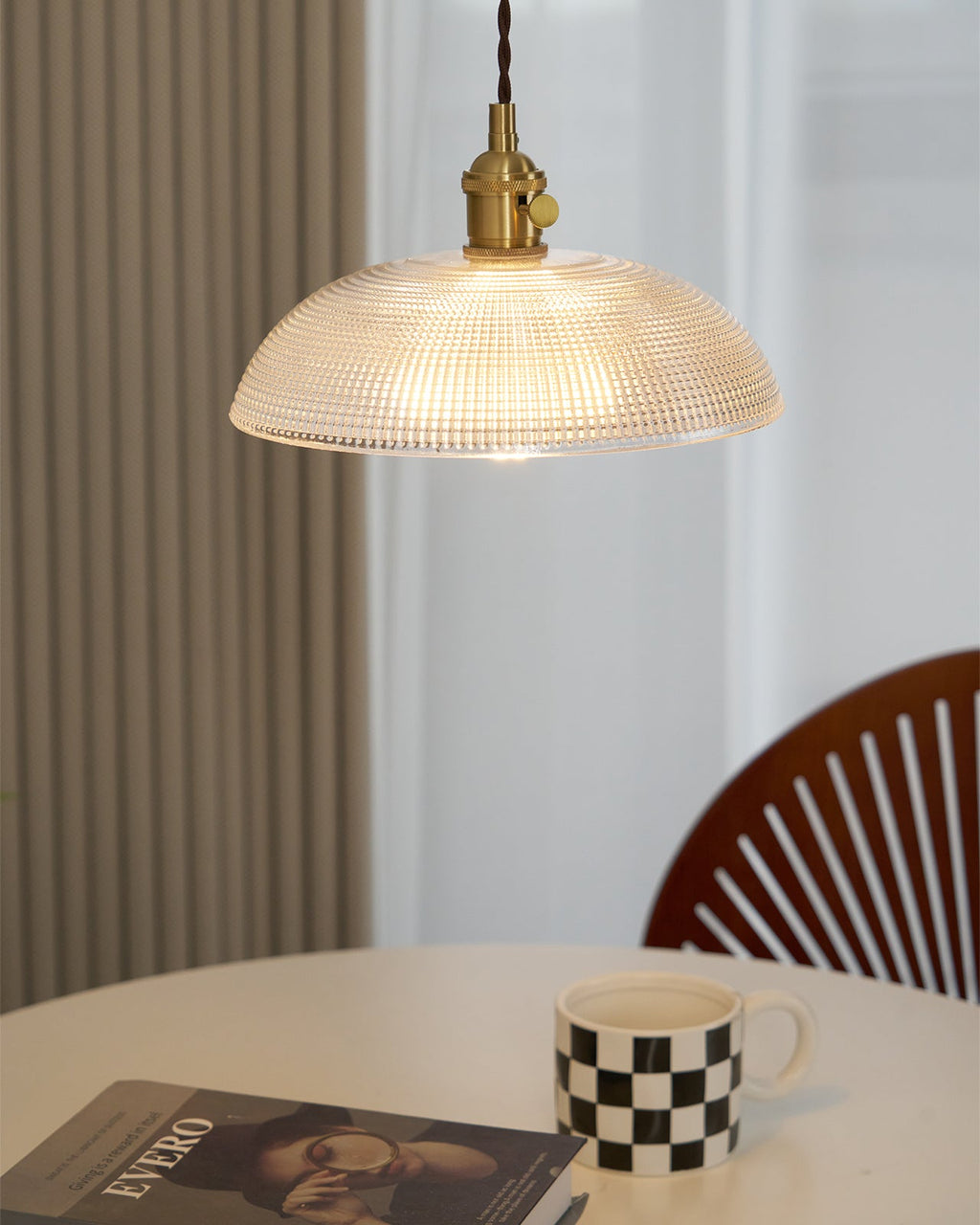 This Clérachic pendant lights a round table set with a chequered mug, a wood chair beside a curtained window.
