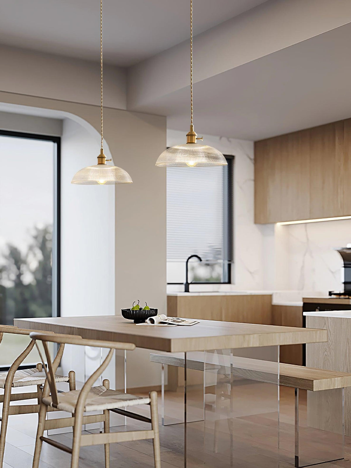Two of these Clérachic pendants hang over a kitchen island with wishbone chairs and a marble backsplash.
