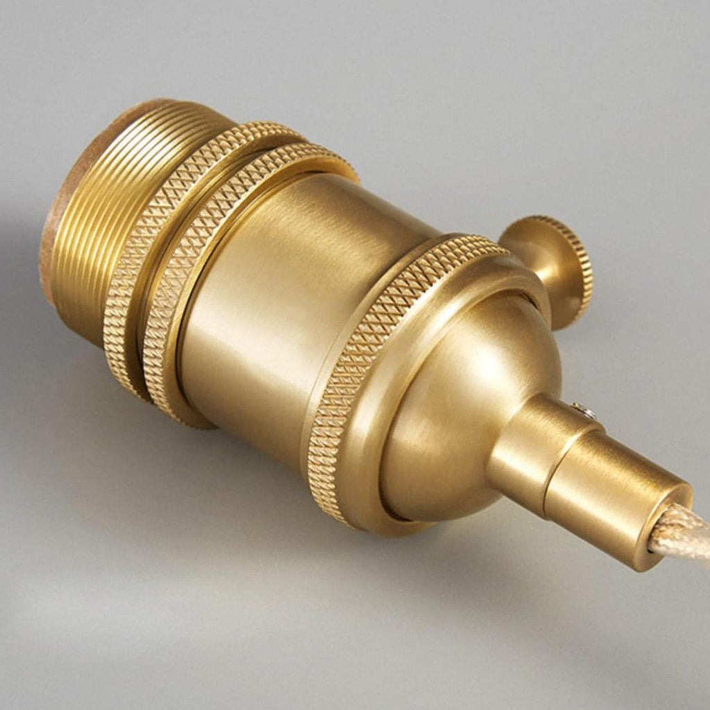 Close-up of this Clérachic pendant's brass socket hardware alone, unattached to its shade, on a plain grey background.