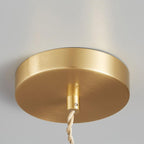 Close-up of the round brass ceiling canopy and cord for this Clérachic pendant, mounted on a white wall.
