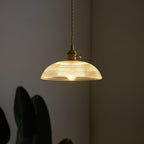 Close view of the lit ribbed glass shade on this Clérachic pendant, its rippled texture catching the light.
