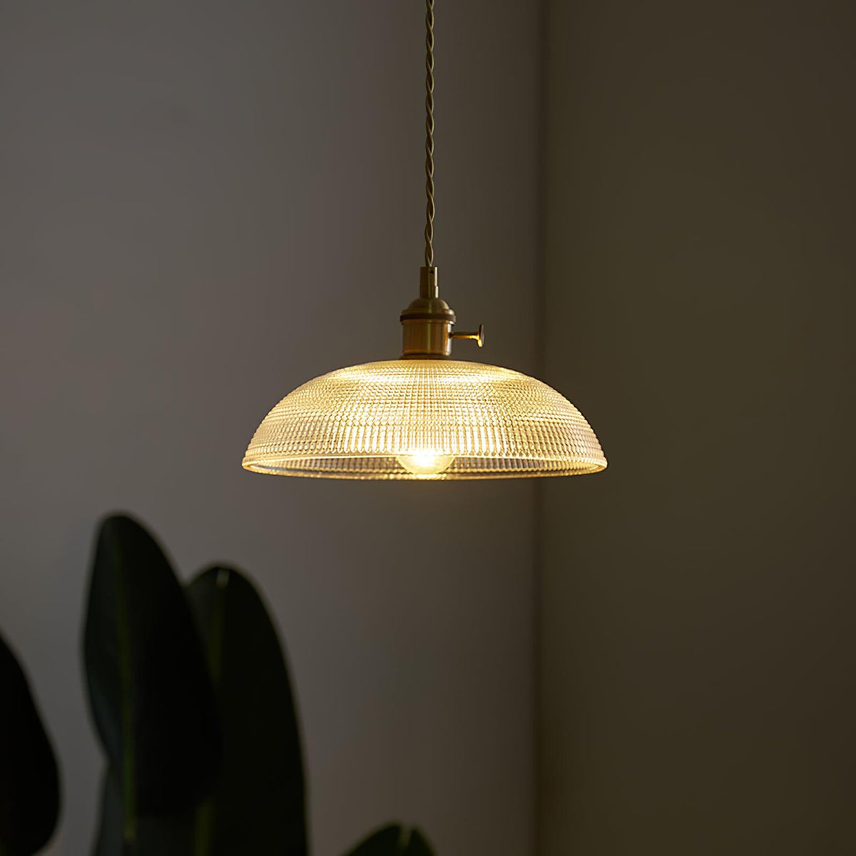 Close view of the lit ribbed glass shade on this Clérachic pendant, its rippled texture catching the light.