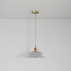 Seen from below, the unlit shade of this Clérachic pendant hangs on a slim brass cord against a white ceiling.