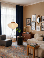Akari floor lamp standing beside a low table and seating