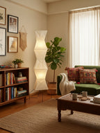 Akari floor lamp glowing softly next to a reading nook
