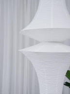 Tall white paper pendant styled in an open stairwell