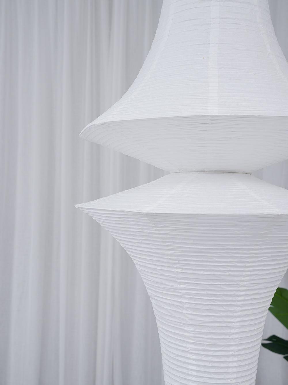 Tall white paper pendant styled in an open stairwell