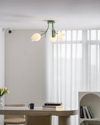 Above a dining table, this Clérachic ceiling light in green hangs unlit with two of its shades clearly visible.