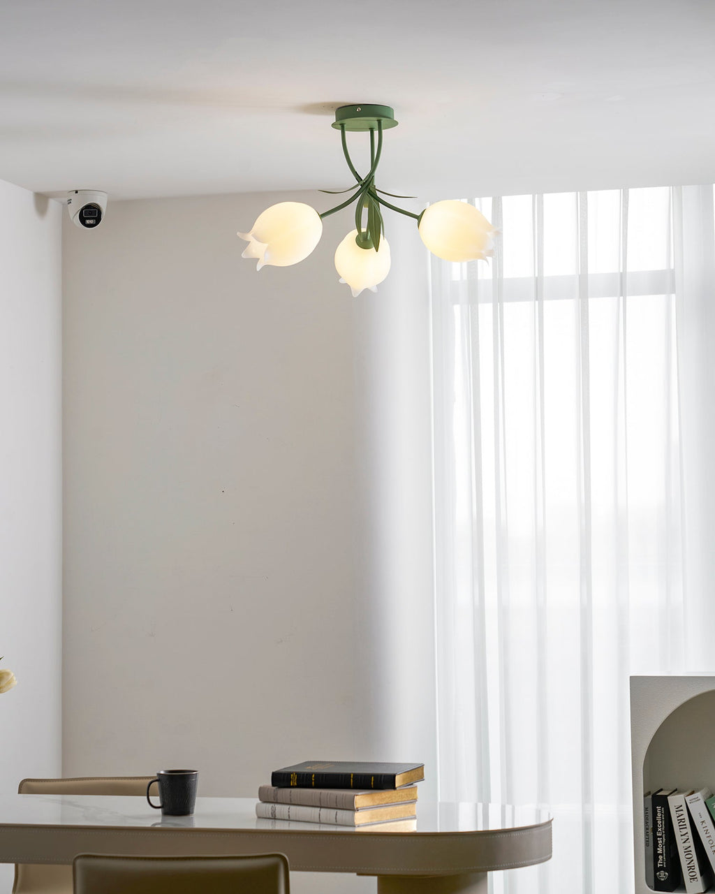 Above a dining table, this Clérachic ceiling light in green hangs unlit, its three shades shown in a wider view.