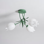 Shown at an angle on a plain background, this Clérachic ceiling light in green displays its three unlit shades.